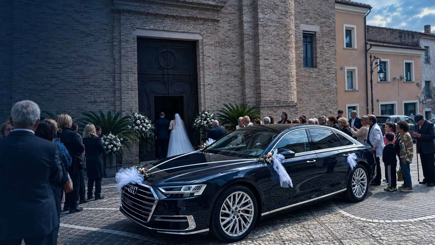 Berlina nera decorata per un matrimonio davanti a una chiesa